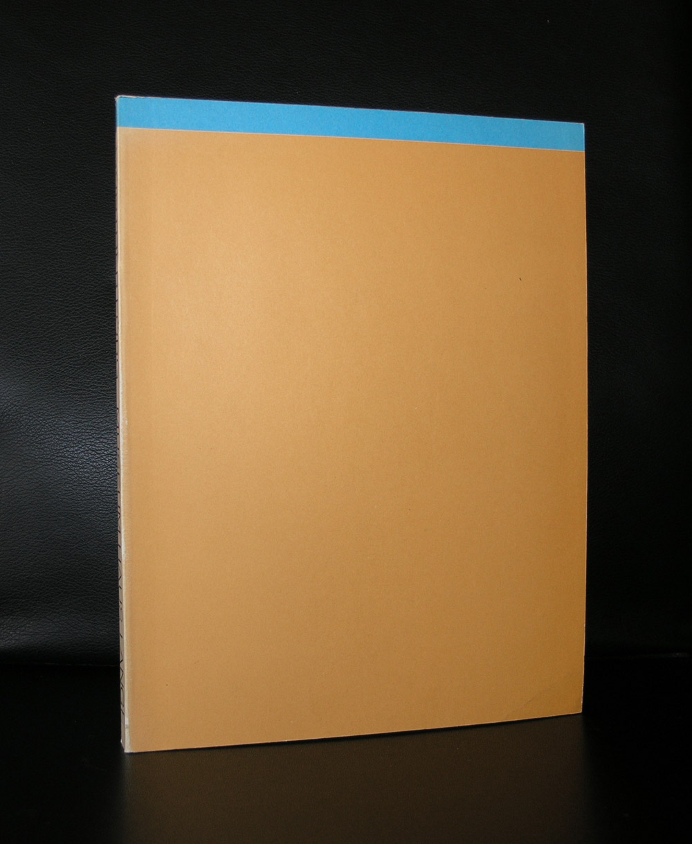 A closed book with a brown cover and a blue top edge, set against a black background.