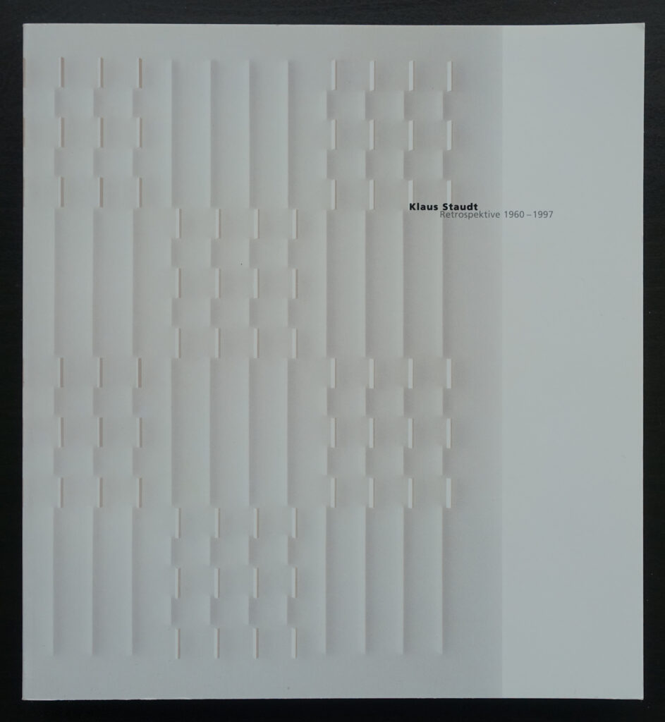 Cover of the Klaus Staudt retrospective exhibition catalog, featuring a textured white design with vertical lines and subtle geometric patterns.