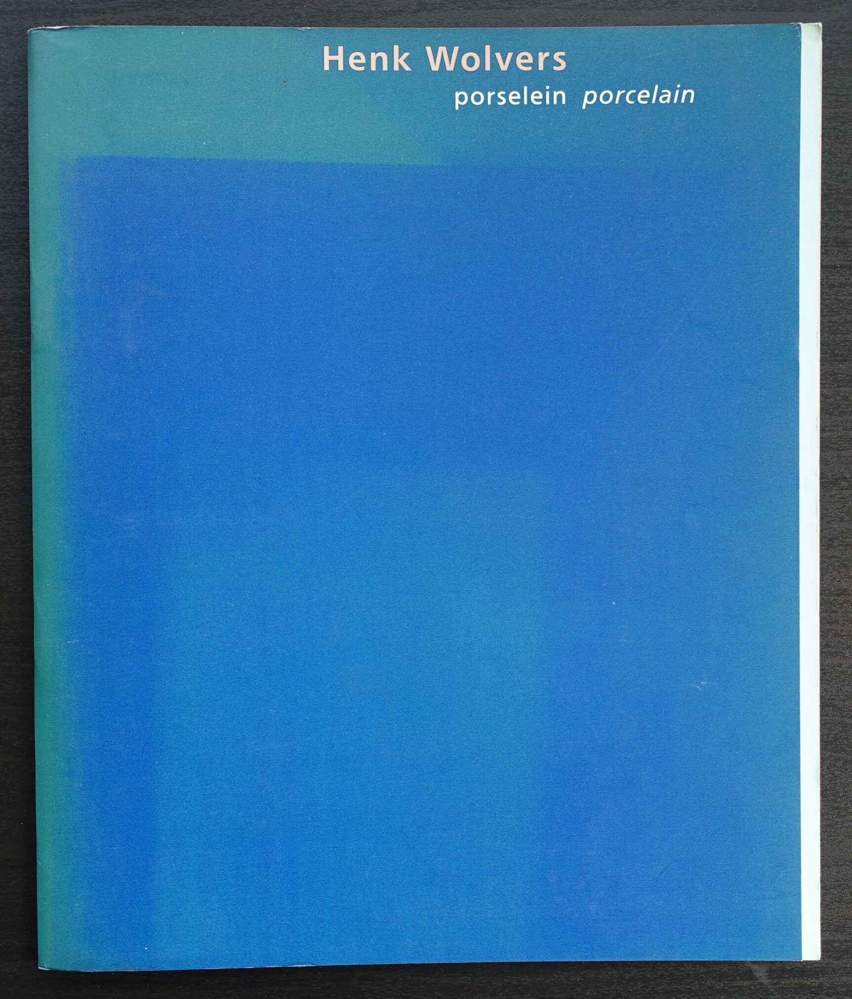 Book cover titled 'Henk Wolvers porselein porcelain' featuring a gradient blue background.